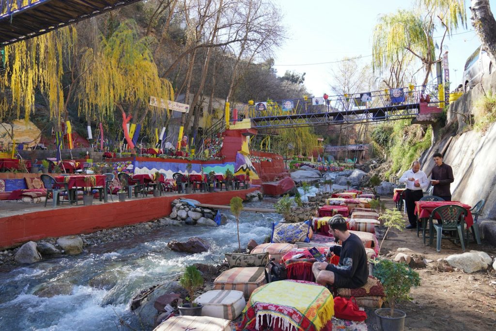 a group of people sitting at a table next to a river