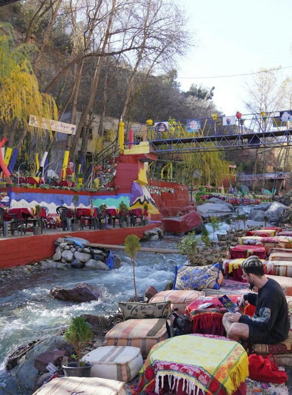 a group of people sitting at a table next to a river