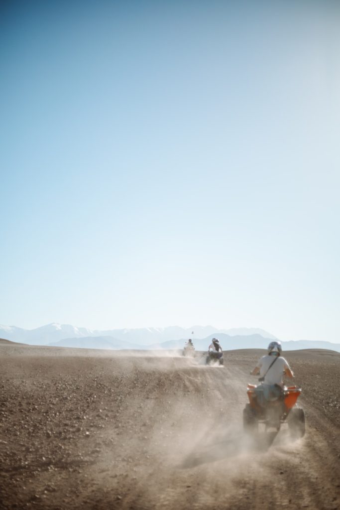 people riding camel on desert during daytime