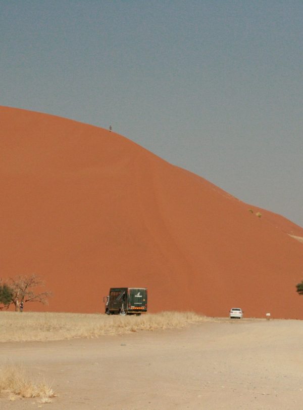 a truck driving down a dirt road in the desert
