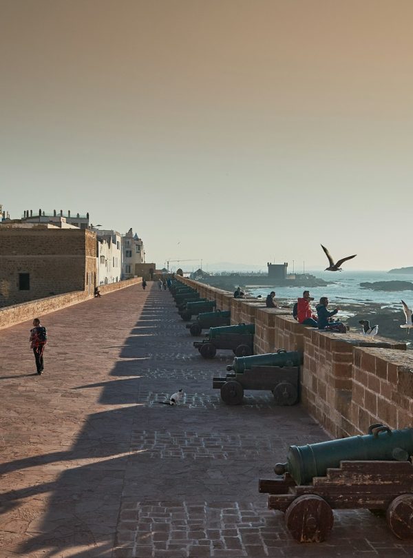 A long wall overlooks the ocean and the city.