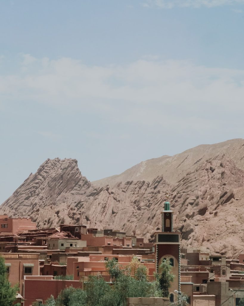 Desert village with mosque and rocky mountains