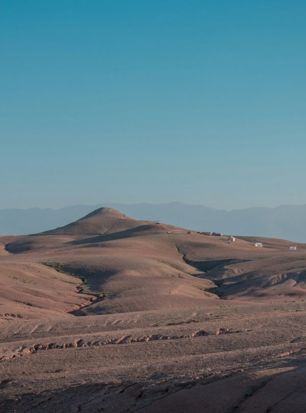 brown sand field under blue sky during daytime